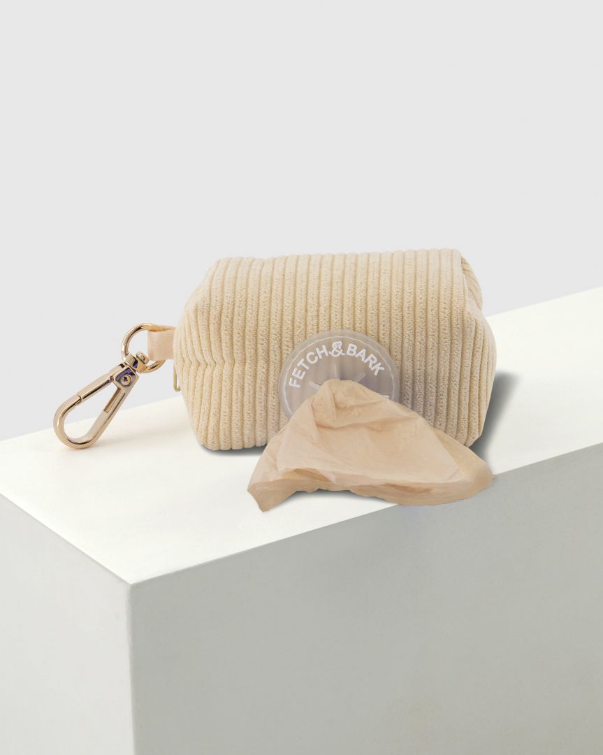 Close-up of the Fetch and Bark Corduroy Waste Bag Holder in Cream, showcasing the premium corduroy texture, gold hardware, and a convenient design for easy waste bag access during walks. Dimensions: 10cm x 6cm for a compact and functional fit.