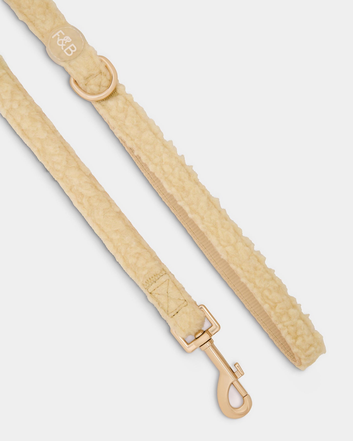 Close-up of the Fetch and Bark Boucle Lead in cream, featuring a boucle texture, durable gold hardware, a high-tensile clip for secure attachment, and a convenient gold D-ring for adding the matching waste bag holder.