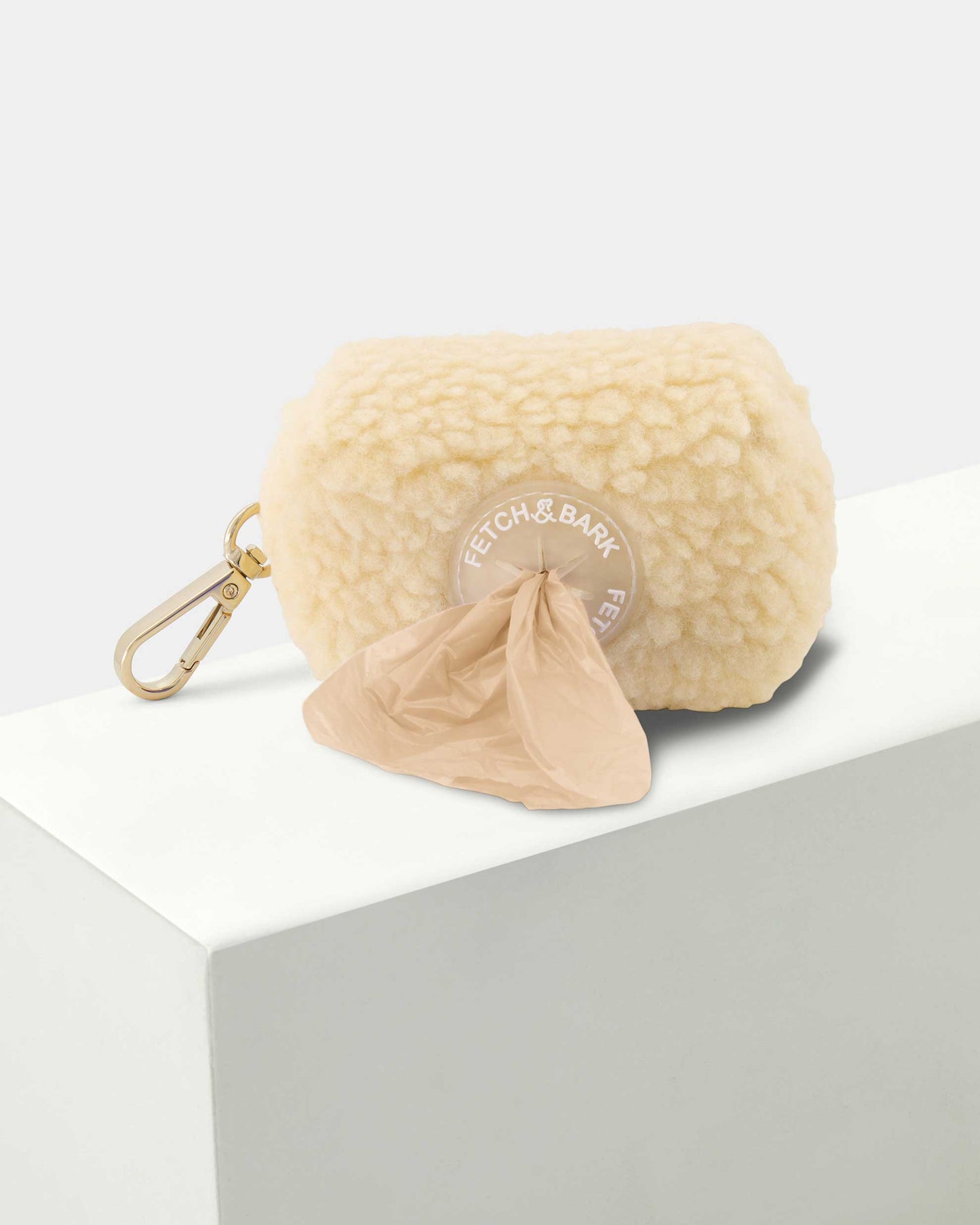 Close-up of the Fetch and Bark Boucle Waste Bag Holder in cream, featuring a stylish boucle texture, secure gold hardware, and convenient design for carrying waste bags during walks