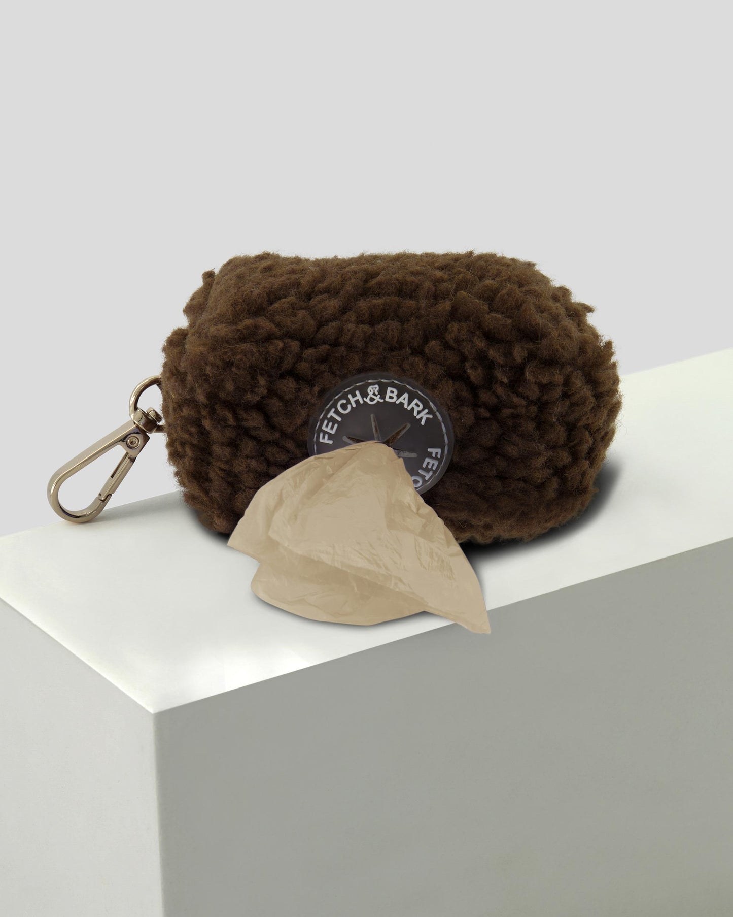 Close-up of the Fetch and Bark Boucle Waste Bag Holder in Chocolate brown, featuring a stylish boucle texture, secure gold hardware, and convenient design for carrying waste bags during walks